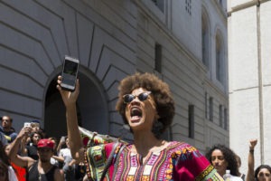 African American Women Bloggers: Black Lives Matter protester shouts during march on City Hall following ruling on LAPD shooting and possible murder of African American female Redel Jones.