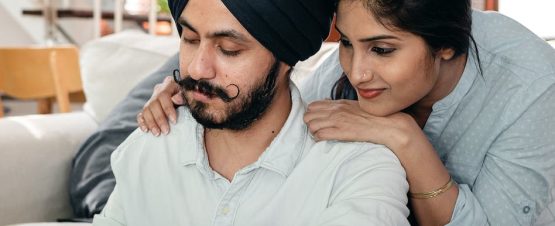 focused young indian couple working at home using calculator